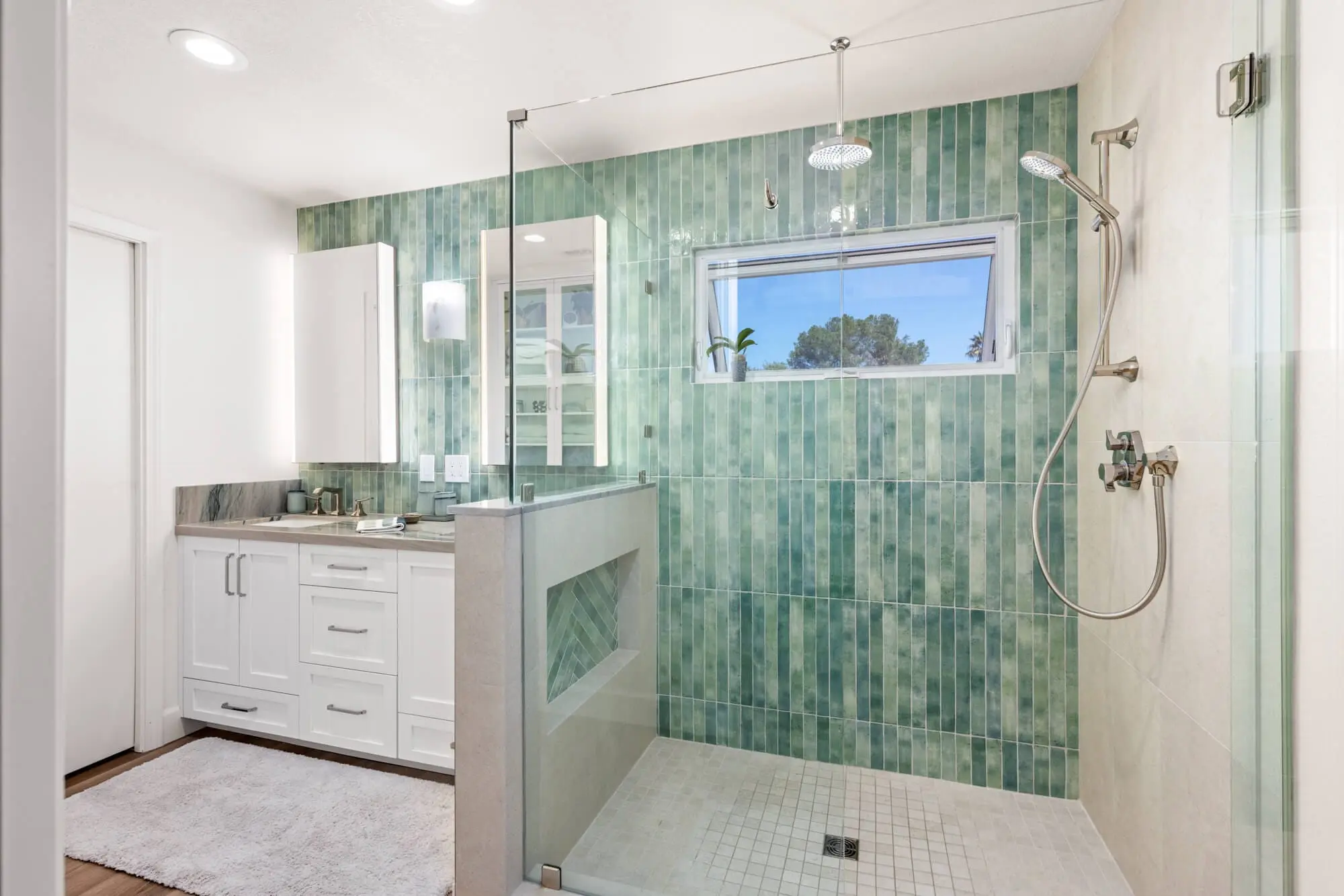 Modern bathroom remodeling with green vertical tiles and a glass shower by Teknik