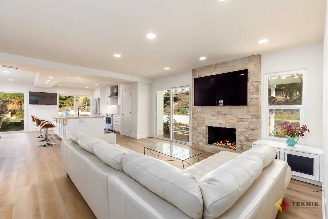 Open-concept living space in Rancho Peñasquitos remodel with stone fireplace and modern kitchen