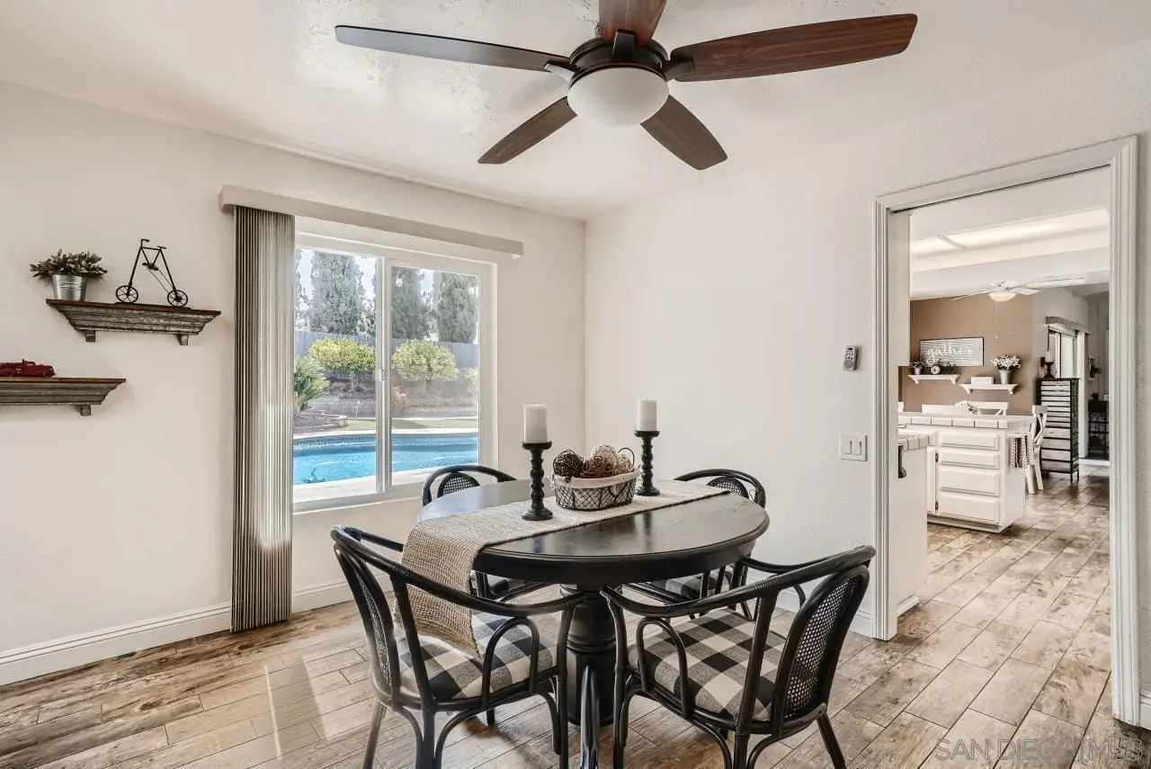 dining area remodel in San Diego with round table checkered chairs and pool view through large window