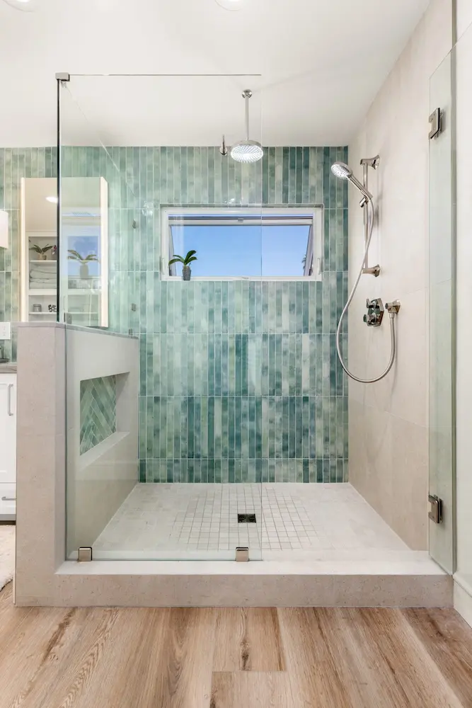 bathroom remodel with walk in shower green vertical tile and wood look flooring